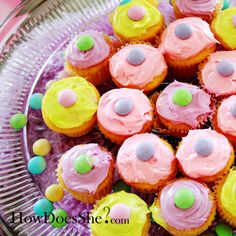 there are many cupcakes with pink frosting on the plate