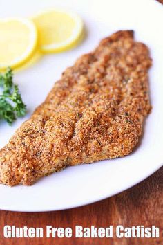 a close up of a plate of food with fish and lemons in the background