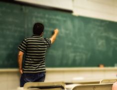 a man standing in front of a chalk board