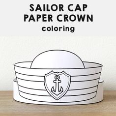 the sailor cap paper crown is sitting on top of a wooden table next to a white wall