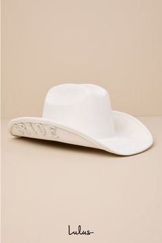 From Nashville to Vegas, the Lulus Last Rodeo White Bride Patch Rhinestone Pearl Cowboy Hat is ready to giddy up and go for all things bachelorette weekend-related! This cowgirl meets bride-to-be hat has a sturdy felt construction that shapes a classic pinched top and an upturned brim adorned with sparkling patches (embellished with shiny rhinestones and faux pearls) that read ""BRIDE"" across each side. 4 inch hard brim, 24 inch interior circumference with an internal drawstring, crown measures 4. 75 inch tall100% Polyester. Imported. Lulus | Last Rodeo White Bride Patch Rhinestone Pearl Cowboy Hat | 100% Polyester. White Bride Cowgirl Hat, Nashville Bachelorette Party Themes, Bride Cowgirl Hat, Bride Cowboy Hat, Western Bachelorette, Last Rodeo, Cowgirl Bachelorette, White Bathing Suit, Bride Hat