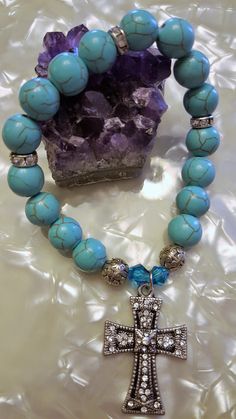 Calling all you Turquoise lovers! If you like a little different twist on your Turquoise, try my Genuine Turquoise Dyed Howlite Beaded Stretchy Bracelet with Crystal-studded Baroque-style cross. Sixteen(16) Genuine Turquoise Dyed Howlite round beads are highlighted by three(3) crystal-studded rondel beads, two(2) round swirly-patterned silver metal beads and two(2) ocean blue conical shaped crystal beads. In the center of the bracelet is a Baroque-style crystal-studded cross.  The Howlite stone, spiritually speaking, is a stone of awareness. It can prepare the user or wearer to receive wisdom and atonement from the Higher Self and the Divine. It is also used for dimensional travel and meditation. Fits a women's 6 1/2 to 7" wrist size. Spiritual Turquoise Beaded Stretch Bracelet, Spiritual Turquoise Beaded Hypoallergenic Bracelet, Bohemian Turquoise Beaded Hypoallergenic Bracelets, Bohemian Hypoallergenic Turquoise Beaded Bracelets, Iron Cross, Style Baroque, Howlite Stone, Baroque Style, Stretchy Bracelets