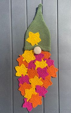 a crocheted gnome hat hanging on the side of a door with lots of stars