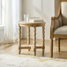 a chair and table in front of a window with a rug on the floor next to it