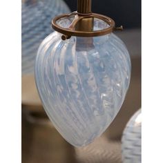 a close up of a light fixture on a table with other lamps in the background