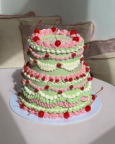 a multi layer cake sitting on top of a white table next to a pillow and chair