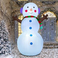 a large snowman in front of a house