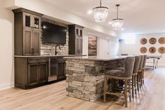 a large kitchen with an island and bar stools