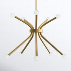 a gold chandelier with white glass balls hanging from it's center point