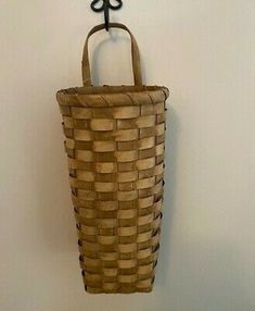 a basket hanging on the wall with a coat rack attached to it's side