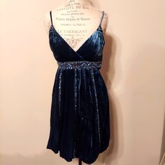 This New With Tags Dress Is In Excellent Condition. The Dress Is A Peacock Blue Silk Velvet With Beading And Sequins At The Empire Waist, Vertically Down The Skirt And At The Front Of The Spaghetti Straps.The Dress Has A Bubble Hem, Is Fully Lined And Has A Side Zipper. The Dress Is A Size 6 But The Brand Runs Small So If You Wear A Size 4, This Dress Will Probably Fit You So Please Check Measurements. Size 6 Bust 34.5 Waist 26 Hip 36 Length 34 Lined Midi-length Prom Dress, Lined Midi Prom Dress, Lined Midi Length Prom Dress, Blue V-neck Holiday Mini Dress, V-neck Fit And Flare Midi Dress For Party, Fit And Flare V-neck Midi Party Dress, Fitted Velvet V-neck Cocktail Dress, Blue V-neck Party Dress, Blue Mini Length Evening Dress For Night Out