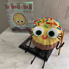 a cupcake with sprinkles on it and a book about the smart cookie