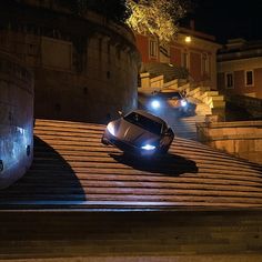 two cars parked on the side of a road at night with their headlights turned on