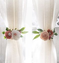 two white curtains with flowers on them in front of a window, one pink and the other red