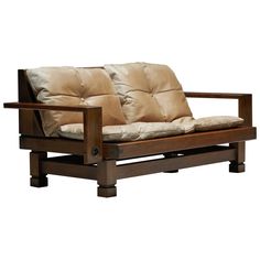 a wooden futon with two pillows on it's back and seat cushion in the middle