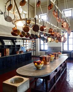 a large kitchen with lots of pots and pans hanging from it's ceiling