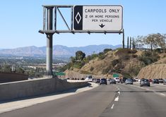 a highway sign on the side of a road that says carpools only 2 or more persons per vehicle