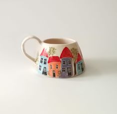 a ceramic mug with houses painted on it