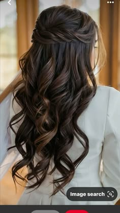 the back of a woman's head with long dark hair and curls on it