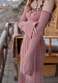 a woman in a pink dress posing for the camera with her hands on her hips