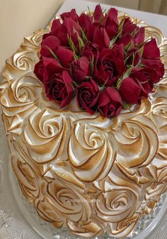 a cake with white frosting and red roses on top