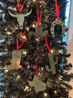 a christmas tree with ornaments hanging from it's branches in the shape of cowboys and longhorns