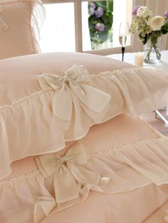 two ruffled pillows are stacked on top of each other