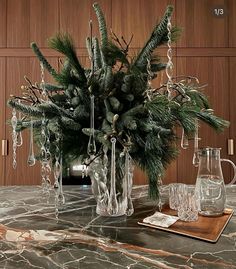 a table topped with a vase filled with green plants