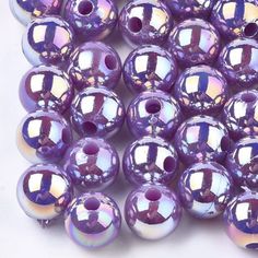 purple glass beads are lined up on a white surface