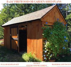 a wooden shed sitting in the middle of a forest with blue flowers growing on it