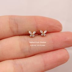 the tiny butterfly earrings are set in gold and clear crystal stones, as well as white crystals