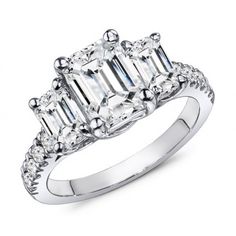 an emerald cut diamond ring with three stone shoulders