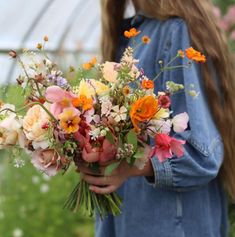 a woman holding a bouquet of flowers in her hands