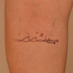 a small tattoo on the leg of a person with a star and moon above it