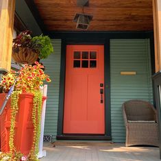 an orange front door on a green house