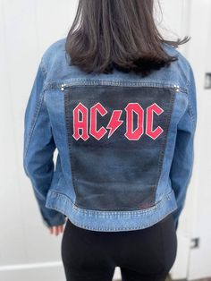 This is an up-cycled, hand painted denim jacket! It is created with fabric paint and nickel rivets. This design is inspired by ACDC. It is de-stressed, riveted, and painted by hand.  Each piece is unique and truly one  -of-a-kind! Brand: Celebrity Pink Wash: Medium Size: L Model size: S Edgy Medium Wash Denim Jacket, Fitted Punk Cotton Denim Jacket, Fitted Cotton Punk Denim Jacket, Fitted Punk Style Cotton Denim Jacket, Rock Style Cotton Outerwear For Fall, Edgy Medium Wash Cotton Denim Jacket, Edgy Spring Festival Denim Jacket, Edgy Denim Jacket For Spring Festival, Trendy Fitted Hand-painted Denim Jacket