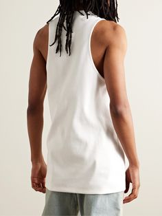 Fear of God's tank top is appliquéd with the label's signature logo patch on the chest. Cut from ribbed stretch-cotton, it has a relaxed shape emphasised by wide armholes and an elongated hem.. Cotton Tank Tops Athleisure Style, Cotton Racerback Tank Top For Streetwear, Stretch Ribbed Tank Top For Streetwear, Stretch Cotton Racerback Tops, Cotton Athleisure Muscle Tee With Racerback, Cotton Stretch Tank Top For Streetwear, Summer Ribbed Cotton Vest, Summer Cotton Ribbed Vest, Sporty Cotton Tank Vest