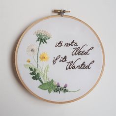 a white wall hanging with embroidery on it that says, is not a week if it's wanted