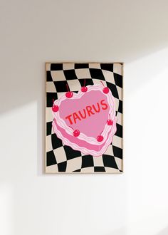 a pink heart with the word taurus written on it is mounted to a white wall