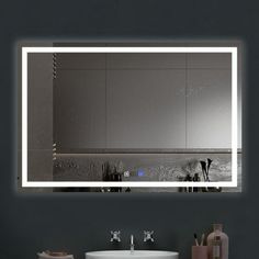 a bathroom with a sink, mirror and lights on the wall above it's counter