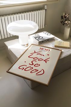 a white table topped with books next to a window