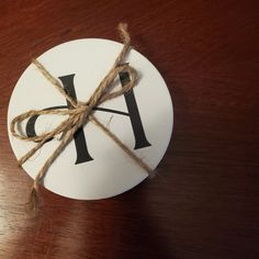 a piece of paper tied with twine on top of a wooden table