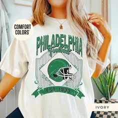 Show off your Philadelphia Eagles pride with this retro t-shirt, designed for women who love vintage style! Featuring an oversized 90's look, this trendy t-shirt is perfect for game day or casual wear. Made from high-quality Comfort Colors fabric, it's an ideal gift for her, a girlfriend, or anyone who loves a classic boho vibe. This retro-style t-shirt is perfect for women who want to support their team in a stylish and comfortable way. Whether it's a sorority gift or a cute game-day outfit, th Philadelphia Eagles Womens Shirts, Retro Oversized Tops For Game Day, Oversized Retro Top For Game Day, Retro Oversized T-shirt For College, Oversized Green Retro T-shirt, Oversized Vintage Green T-shirt, Green Oversized Vintage T-shirt, Philadelphia Eagles Shirts, Eagles Shirt