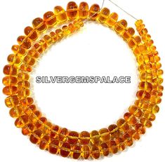 three strands of yellow glass beads on a white background