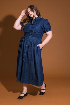 A washed denim midi dress featuring shirt collar, button down, short puff sleeve, front pockets and full skirt Details: Self : 90% Cotton 10% Polyester Size & Fit - Model is 5`8" And Wearing Size Small- Measurements Taken From Size Small- Approx. Length: 51" Denim Midi Dress With Pockets And Short Sleeves, Medium Wash Denim Midi Dress With Short Sleeves, Denim Blue Short Sleeve Midi Dress, Short Sleeve Denim Blue Midi Dress, Denim Midi Dress With Short Sleeves For Work, Denim Blue Short Sleeve Shirt Dress, Dark Wash Short Sleeve Dress With Button Closure, Denim Midi Shirt Dress With Pockets, Denim Midi Length Shirt Dress With Pockets