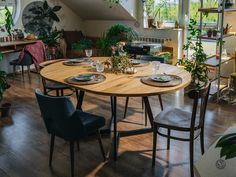 a dining room table with chairs and plates on it in front of an open floor plan