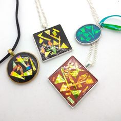 These unusual pendants are made from a rhodium plated, nickel free stainless steel base by Pebeo which is decorated with a base of coloured polymer clay with pieces of dichronic film covered with a resin finish.   The dichronic film changes colour with the direction of light.  Each of the pendants has the same dichronic film but the background colour changes how it looks. The square shape pendants are 3.2cm square and the chains are 41cm long. The green oval pendant is 2.8cm long and 2.2cm wide and is threaded onto toning green and blue ribbons and is adjustable in length between 44-49cm. The the square and oval pendants have plain silver colour backs. The black round pendant is 3cm diameter, has a gold colour base and is threaded onto black, silky rat tail cord and is adjustable between 4 Green Oval, Oval Pendant, Blue Ribbon, Round Pendant, Square Shape, Rhodium Plated, Silver Color, Colorful Backgrounds, Jewelry Necklace Pendant