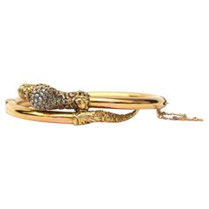 This magnificent antique creation of the Victorian era is a reptile bracelet dating from the mid-to-late 19th century - the snake is artfully created in yellow gold and set with ruby eyes and the serpent head is inlaid with old cut diamonds. It is a light hollow hinged bangle bracelet. The head and tail of this reptile have an ornate floral design while the rest of the gold is structured which resembles the scales of the snake. The bangle is slightly oval shaped with a side hinge, there is a sma Luxury Victorian Gold Bracelet, Serpent Jewelry, The Victorian Era, Heads And Tails, The Serpent, Snake Bracelet, The Snake, Queen Victoria, Hinged Bangle