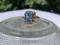 This beautiful ring features design notes of both the Art Deco period and the oncoming Wartime 1940's. The Topaz is also Vintage, and was recently set by a professional jeweler.  It is a size 7.5 Antique Sapphire Birthstone Ring For Formal Occasions, Vintage Gold Topaz Birthstone Ring, Collectible Vintage Sapphire Ring, Vintage 14k Stamped Sapphire Ring Collectible, Vintage Blue Topaz Round Ring, Vintage Blue Topaz Ring In 14k Gold, Vintage Sapphire Ring With Prong Setting, Vintage Blue Topaz Ring With Prong Setting, Vintage Blue Topaz Hallmarked Ring