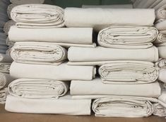 a stack of folded white sheets sitting on top of each other